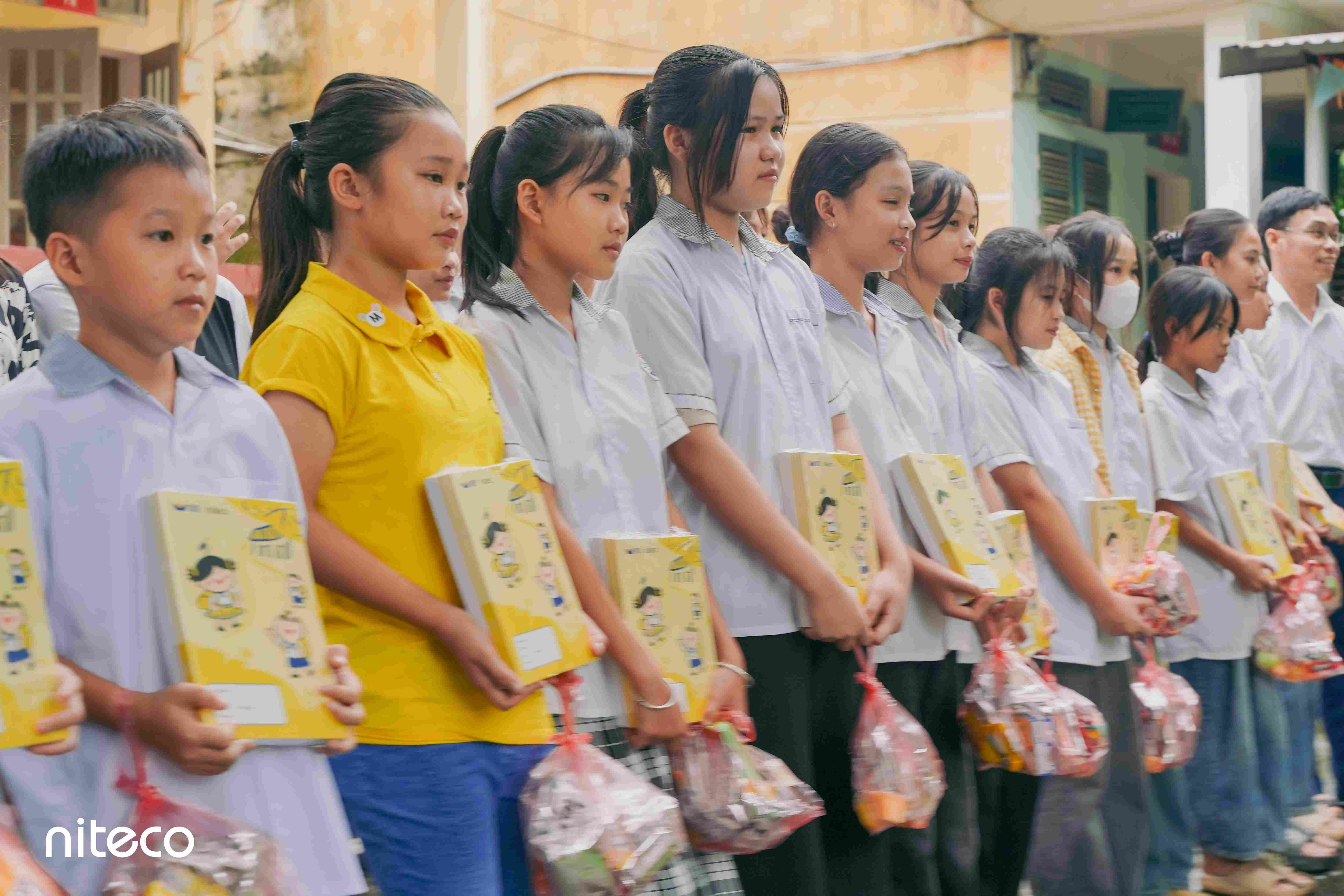 Students receiving notebooks and gift sets