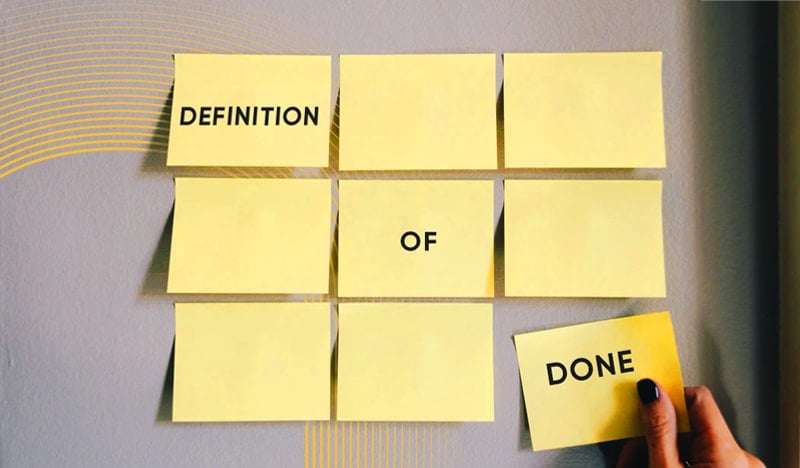 Yellow sticky notes spelling "Definition of Done" on a gray wall background