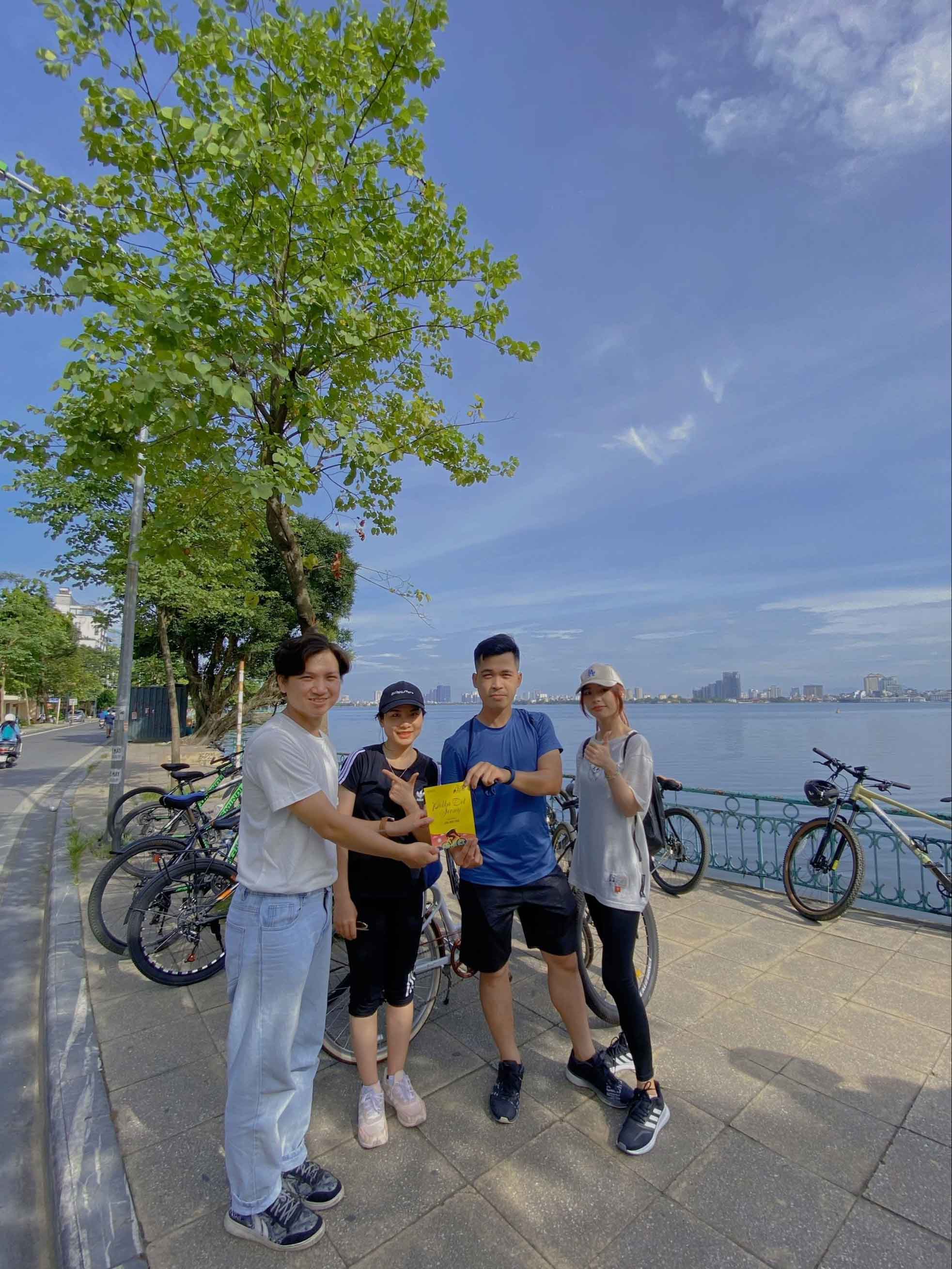 Four friends enjoying a cycling trip by the waterfront on a sunny day