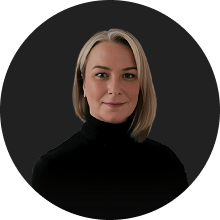 Professional portrait of a confident woman with short blonde hair and black turtleneck