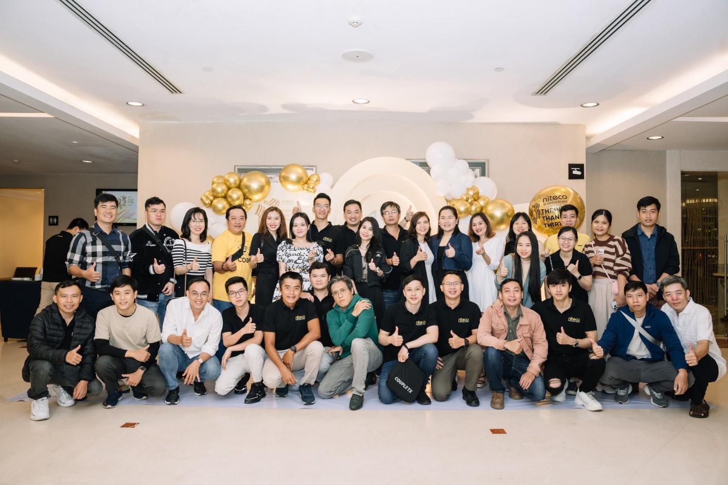 Team Niteco celebrating the company's 11th anniversary with gold and white balloons