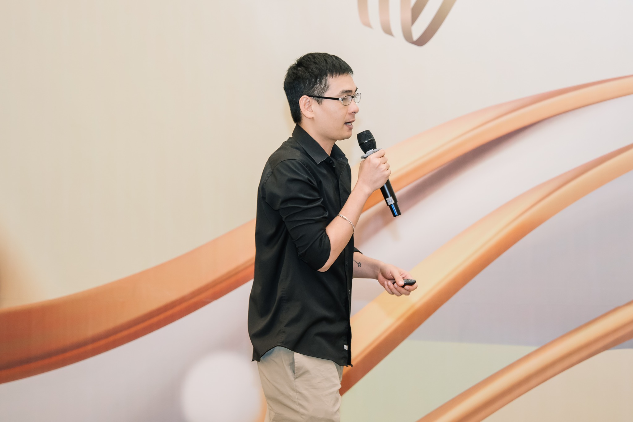 Man presenting with microphone and clicker during professional seminar