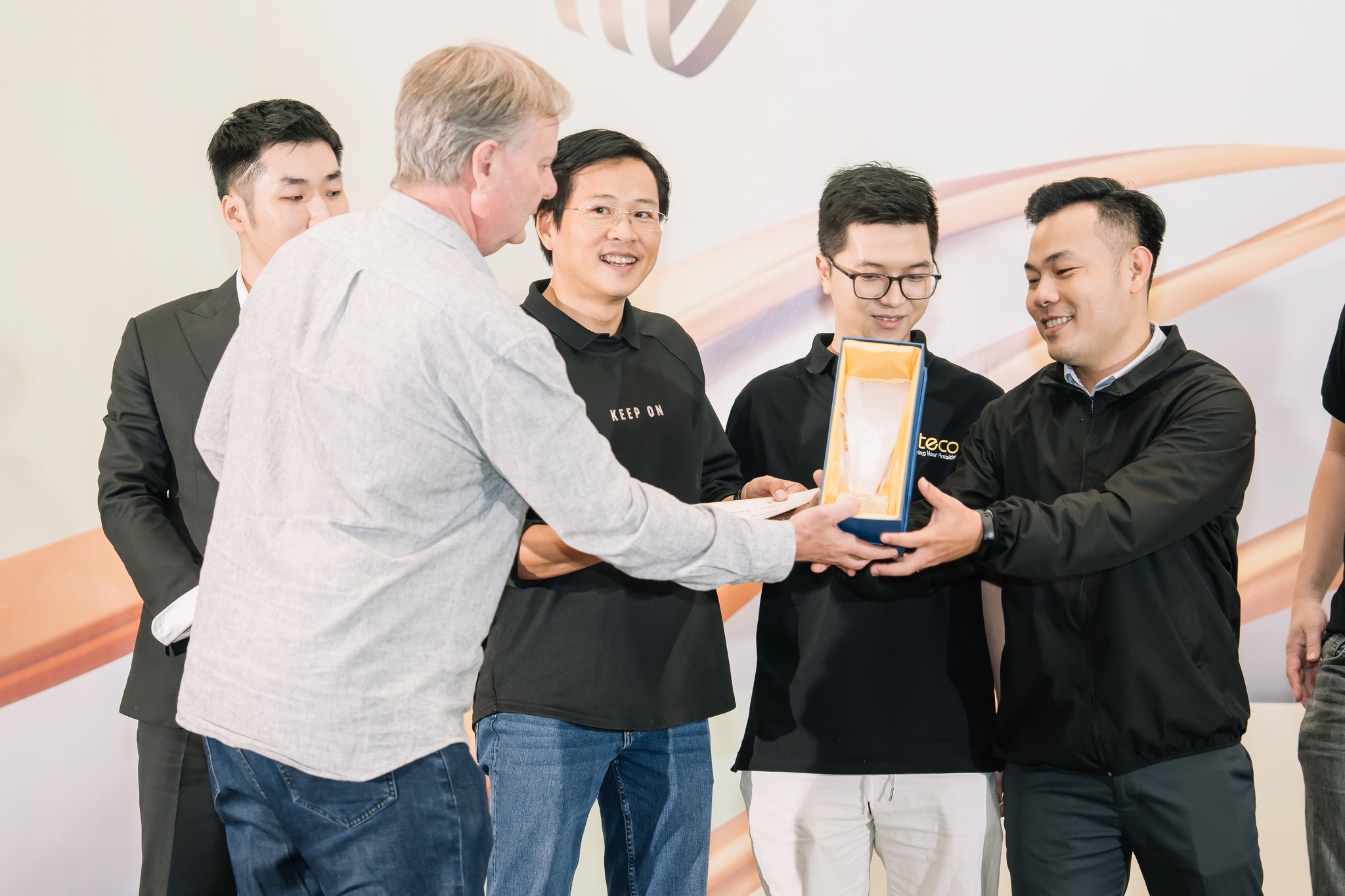 Award ceremony showing team receiving innovation award and recognition trophy