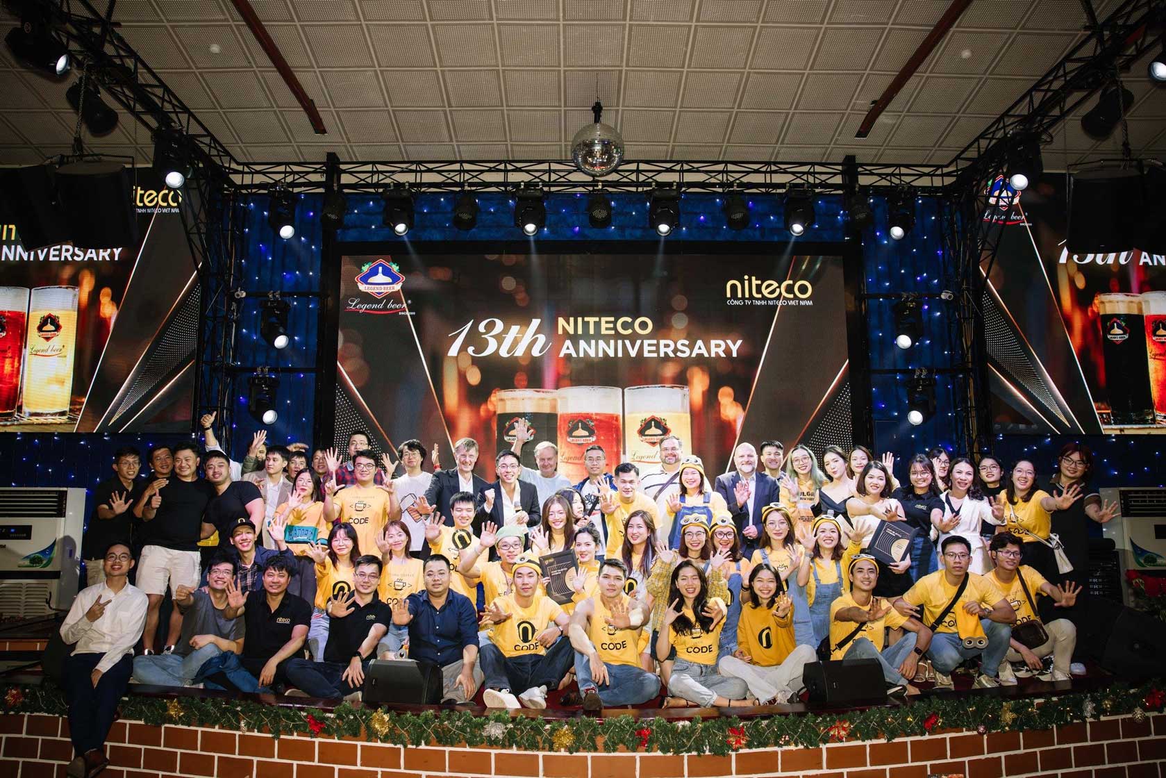 13th Niteco Anniversary group celebration on stage with smiling team members
