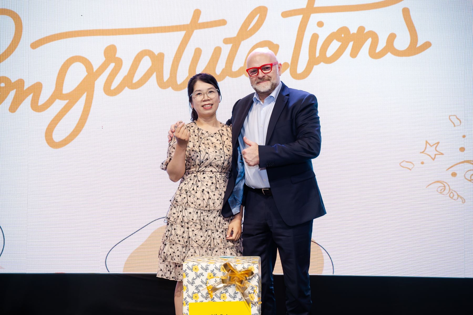 CEO awarding prize to lucky draw winner on stage