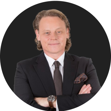 Confident male professional in black suit and tie with folded arms