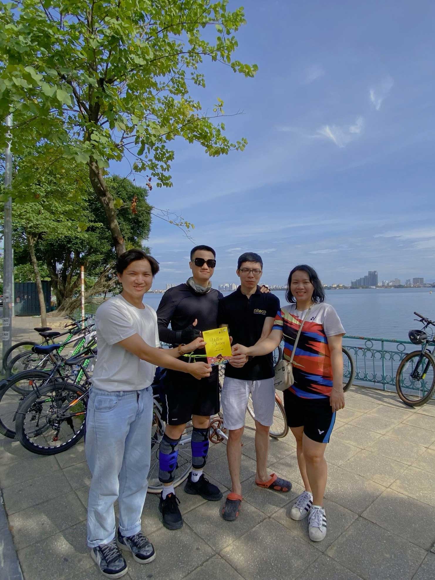 Four friends enjoying a cycling trip by the waterfront on a sunny day