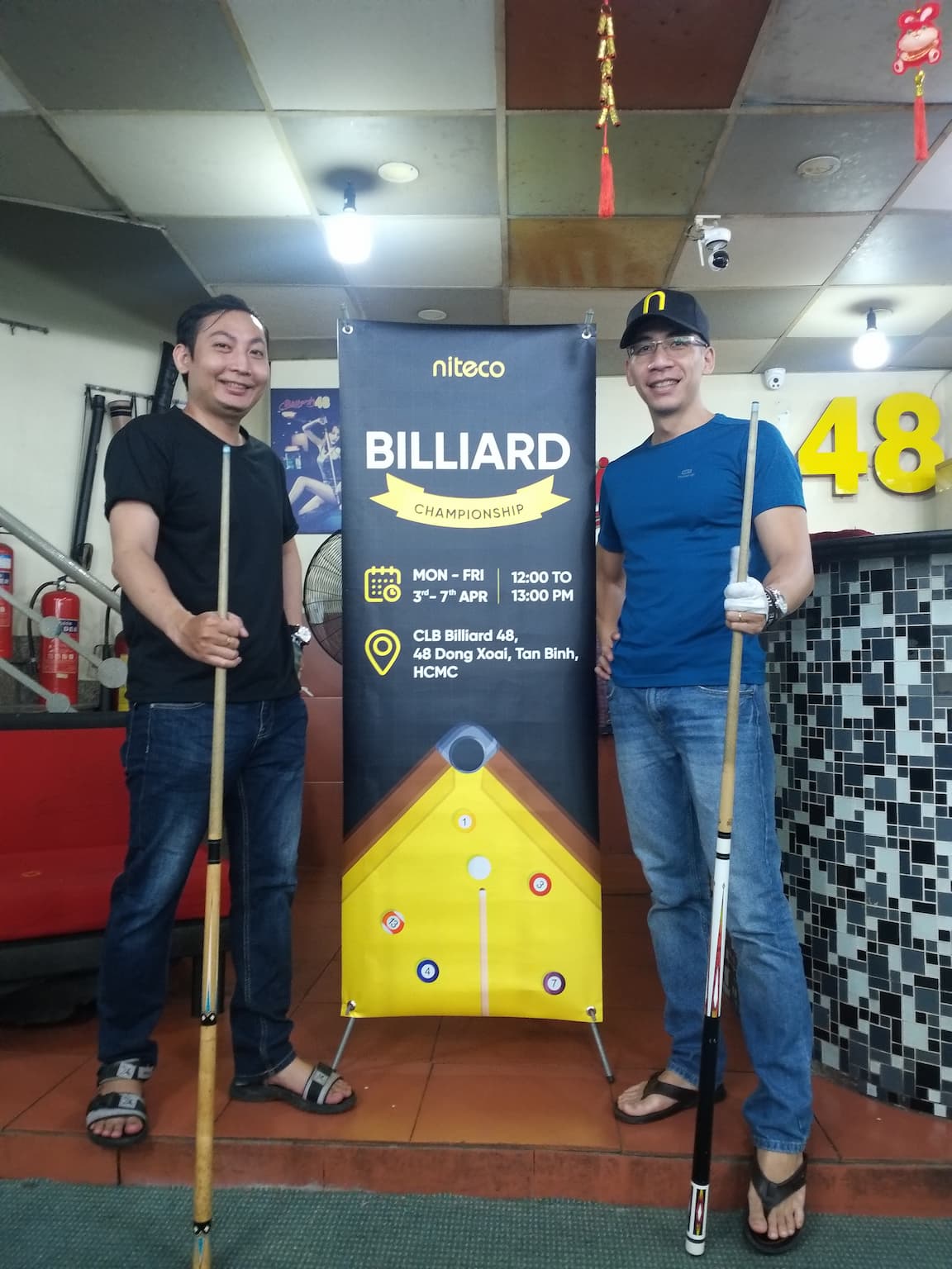 Niteco staff posing in front of the Niteco Billiards Club banner