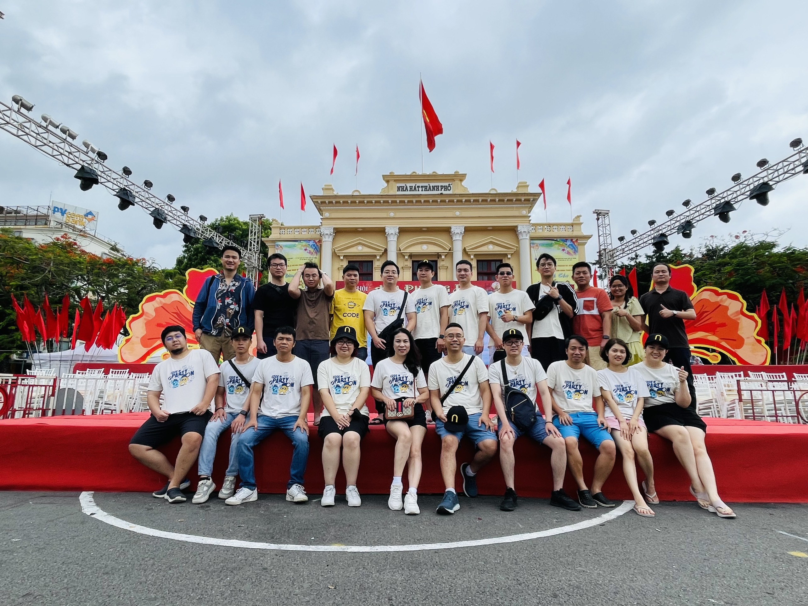 Group celebrating Code Party at Nhà hát Thành phố with red flags and stage setup