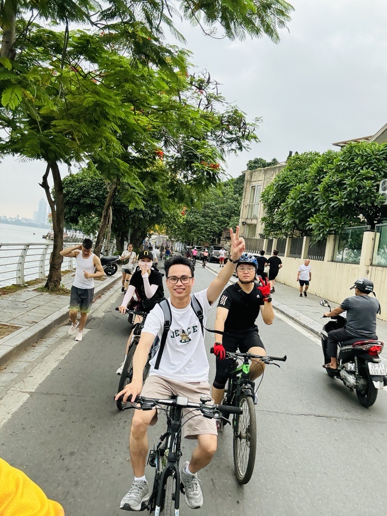 Young cyclists enjoying cycling on a tree-lined urban riverside path