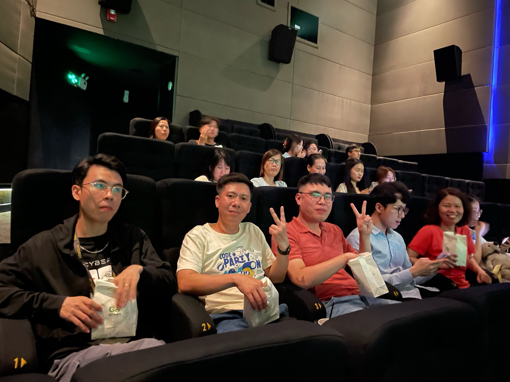 People enjoying popcorn at a movie theater during a group movie outing