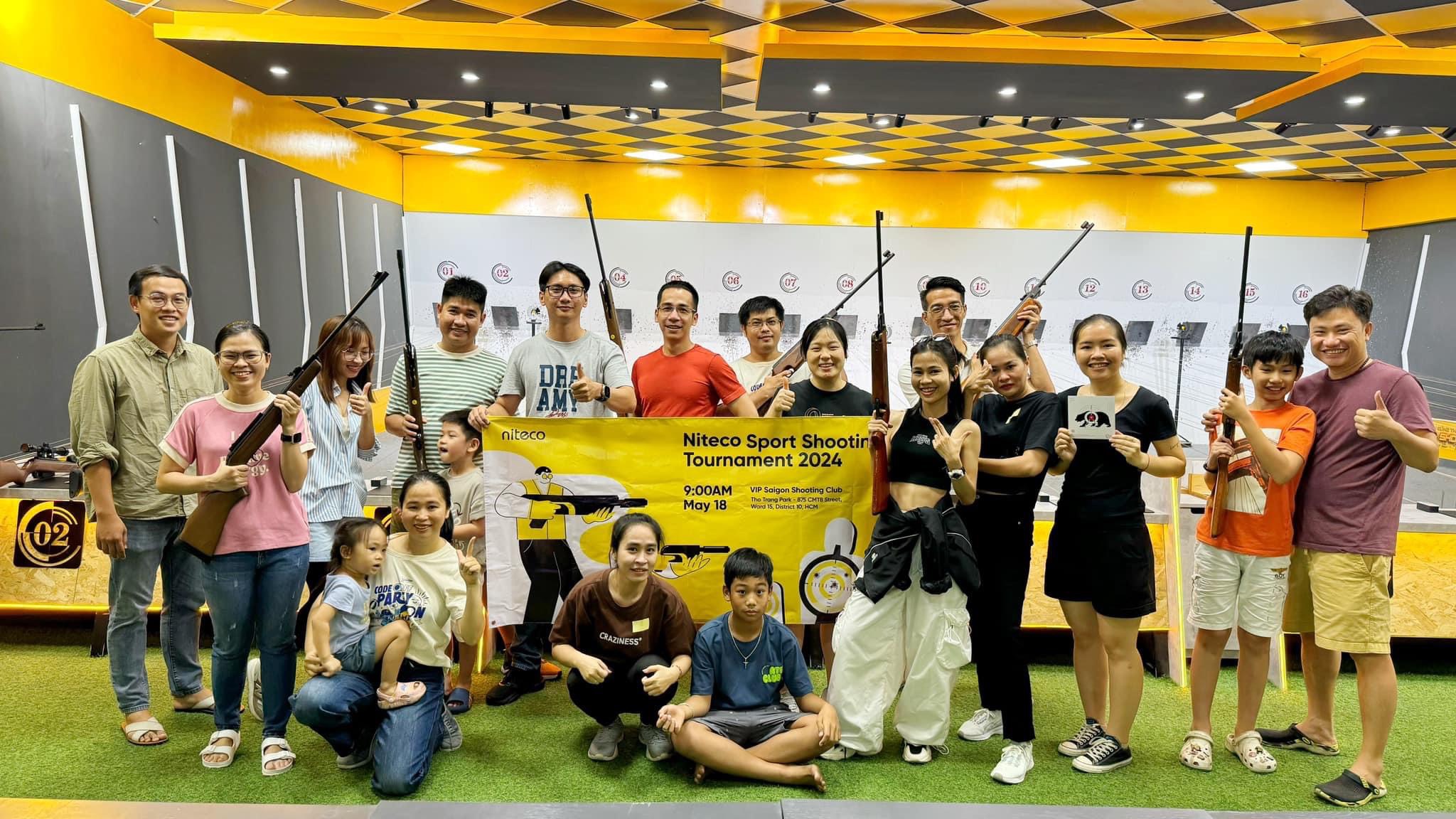Group celebrating Niteco Sport Shooting Tournament 2024 with rifles at shooting range