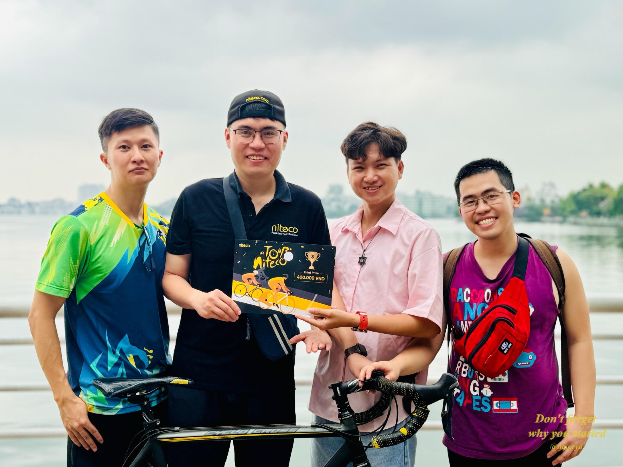 Tour de Niteco cycling event winners holding prize certificate by the lake