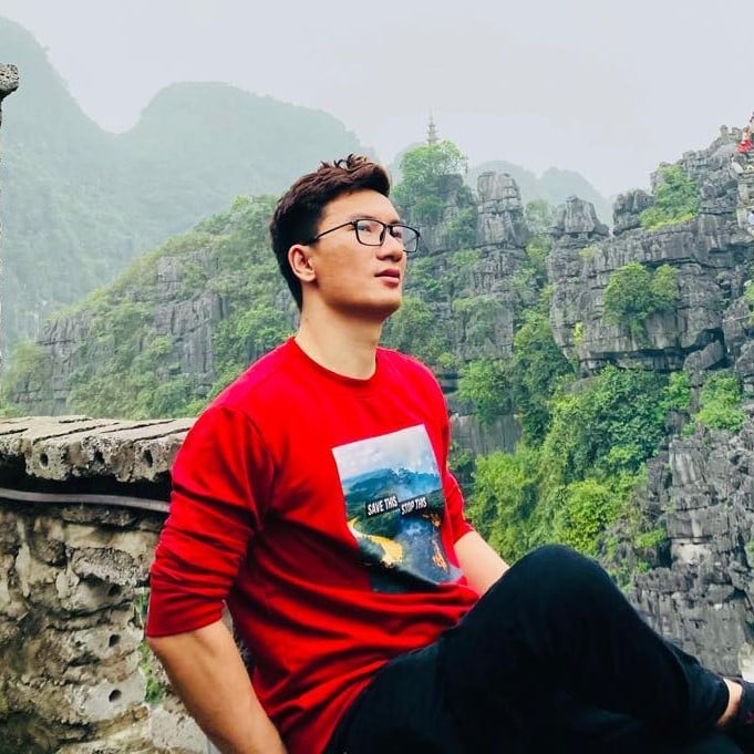 Runner wearing a red shirt jogging outdoors with cityscape and mountains background