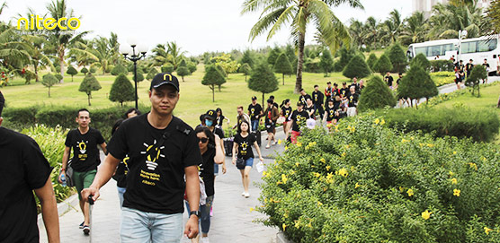 Group of volunteers walking in a green park during Liteco community event